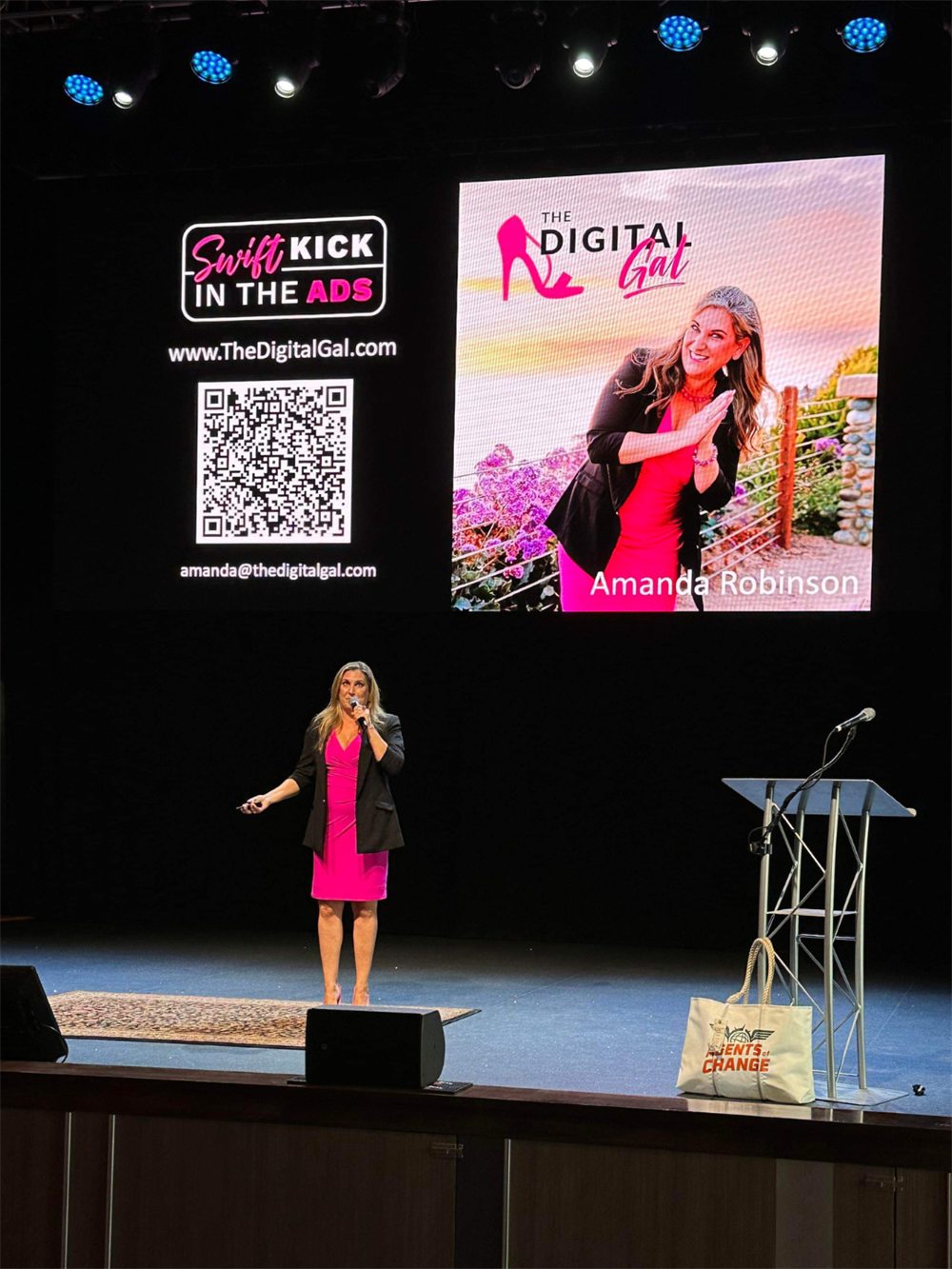 Amanda Robinson speaking on stage in front of a Swift Kick in the Ads screen