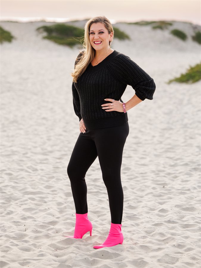 Amanda on the beach with her hands on her hips